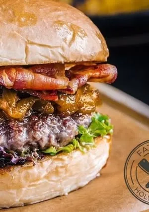 Burger sa slaninom, karamelizovanom paprikom i zelenom salatom u brioš pecivu.